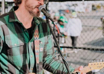 Close-up of guitarist singing into a microphone at the 2025 Poulsbo Beer Run in Poulsbo, Washington.
