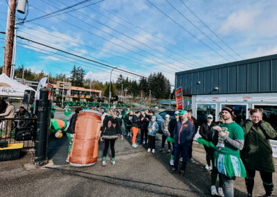 Festive crowd wearing green outfits lining the street during the 2025 Poulsbo Beer Run event.