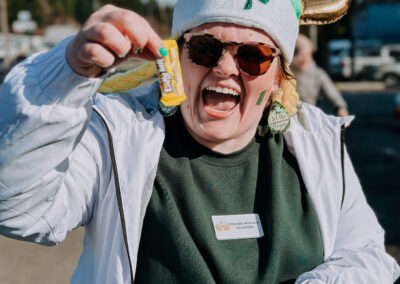 Smiling volunteer wearing a shamrock Viking hat handing out candy at the 2025 Poulsbo Beer Run.