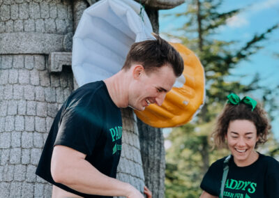 Two participants laughing beside the Norseman statue at the 2025 Poulsbo Beer Run in downtown Poulsbo.
