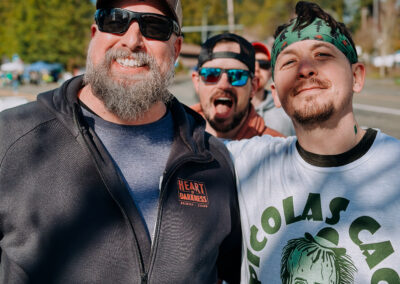 Group of friends smiling and posing in green attire at the 2025 Poulsbo Beer Run.