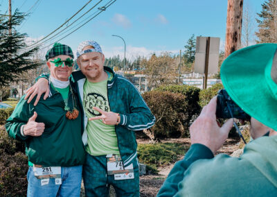 Two participants posing for a photo while a friend takes their picture at the 2025 Poulsbo Beer Run.