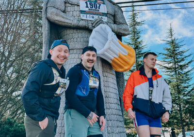 Three runners standing at the Norseman statue during the 2025 Poulsbo Beer Run in Poulsbo, Washington.